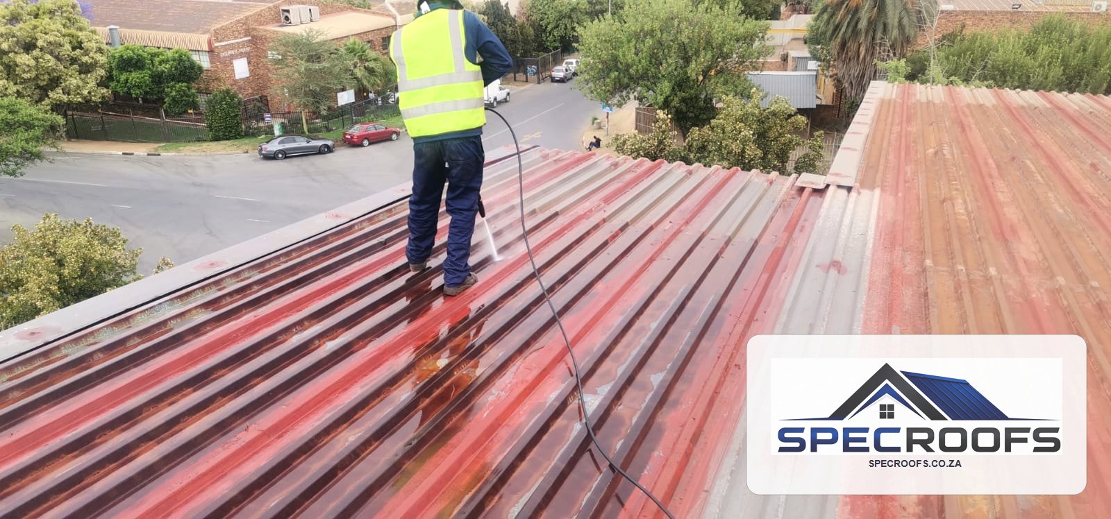 Specroofs technician cleaning a metal roof before treatment