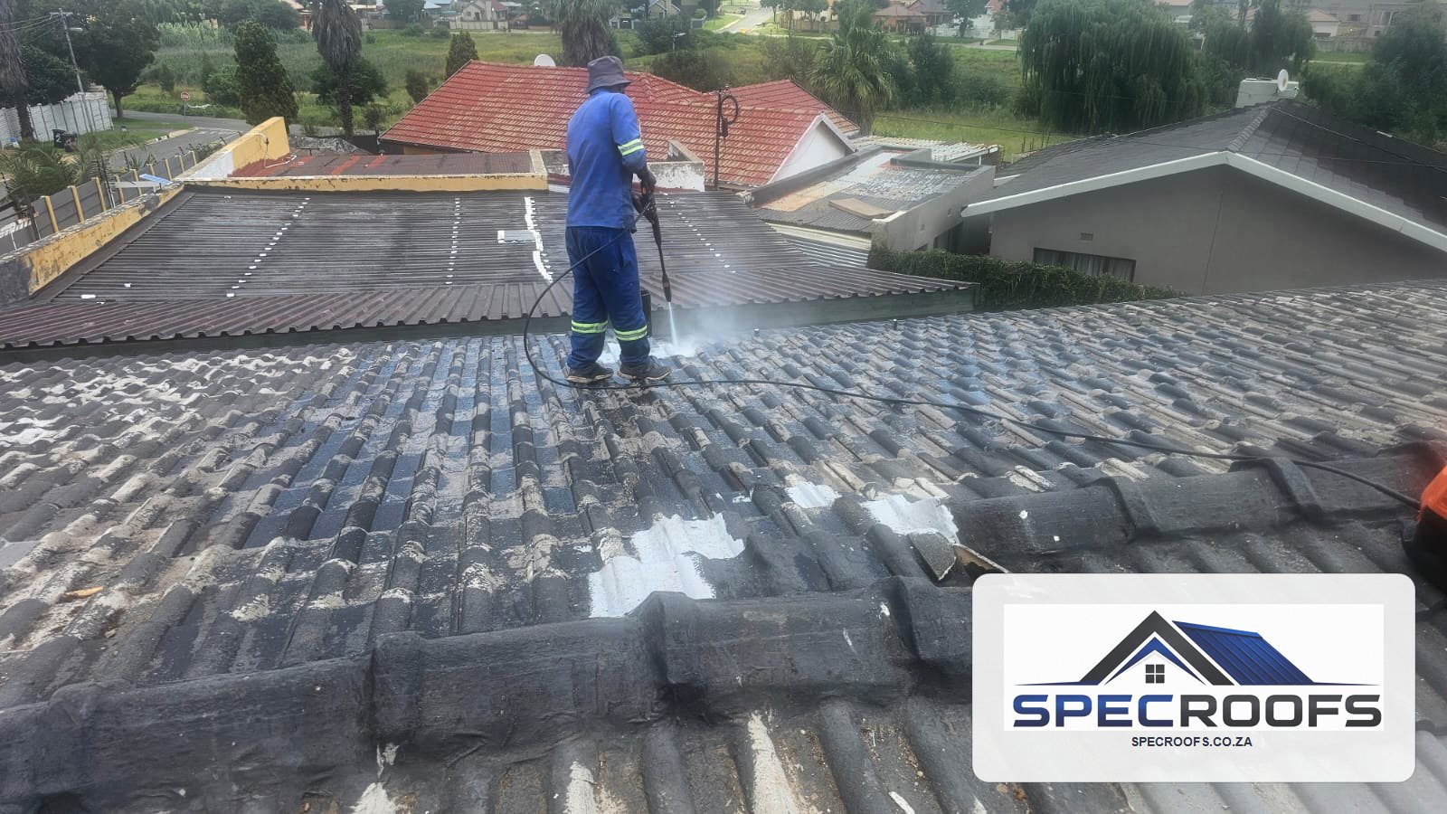 Specroofs technician cleaning and maintaining a tiled roof